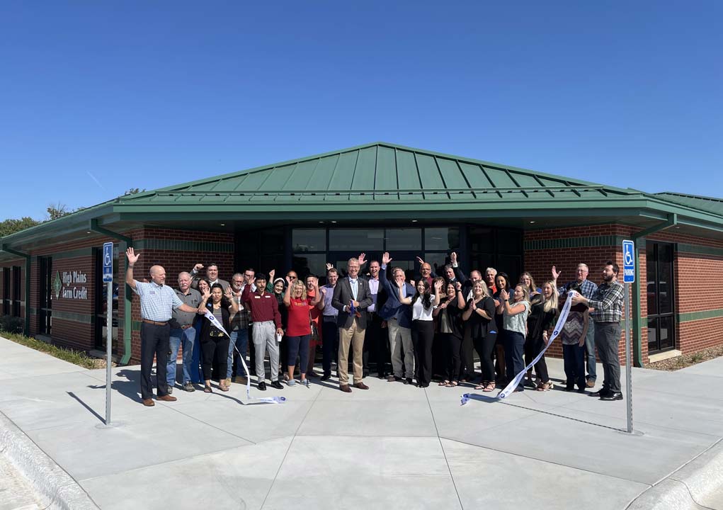 HPFC staff, directors, and members from the community cheer after cutting the ribbon in front of the new Dodge City office building.