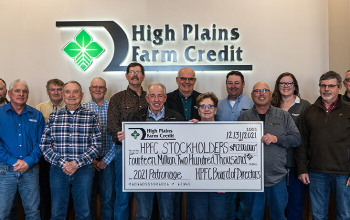 The High Plains Farm Credit Board of Directors poses with a large check, declaring record patronage of $14.2 million for the 2021 year.