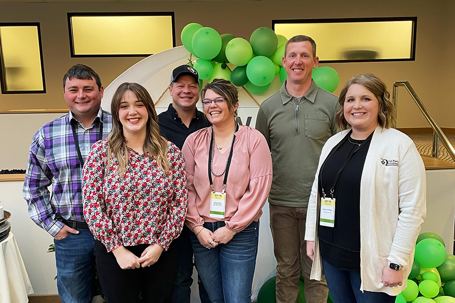 HPFC Vice President Loan Officer, Sarah Linenberger, poses with young, beginning, and small borrowers in front of a balloon-covered sign at the GYFF event.