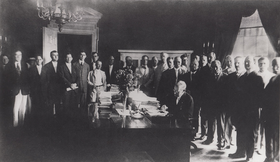 President Wilson signs legislation creating the Federal Land Bank System in 1916.