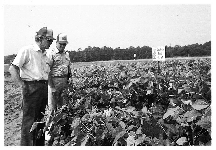 Two farmers inspect a field during the Farm Crisis of the 1980s.