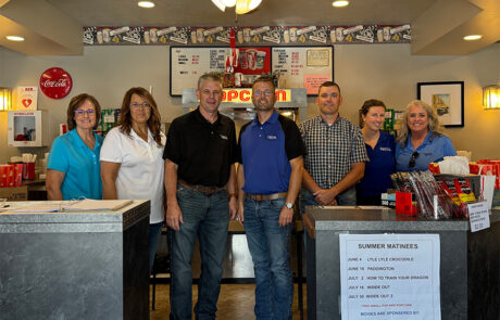 Staff from the HPFC office in Larned stands behind the movie counter at the State Theater in Larned.