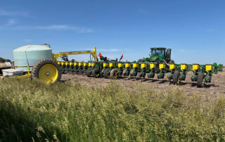 Q3 2026 Calendar Photo Contest Winner. Tractor and planting equipment stand at the edge of a field, ready for fall planting. Submitted by Brenda Boese.
