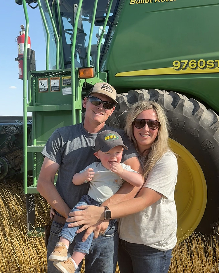 High Plains Farm Credit customer-stockholder and nominating committee member, Lindy McMillen, and her family stand in front of a combine during wheat harvest.