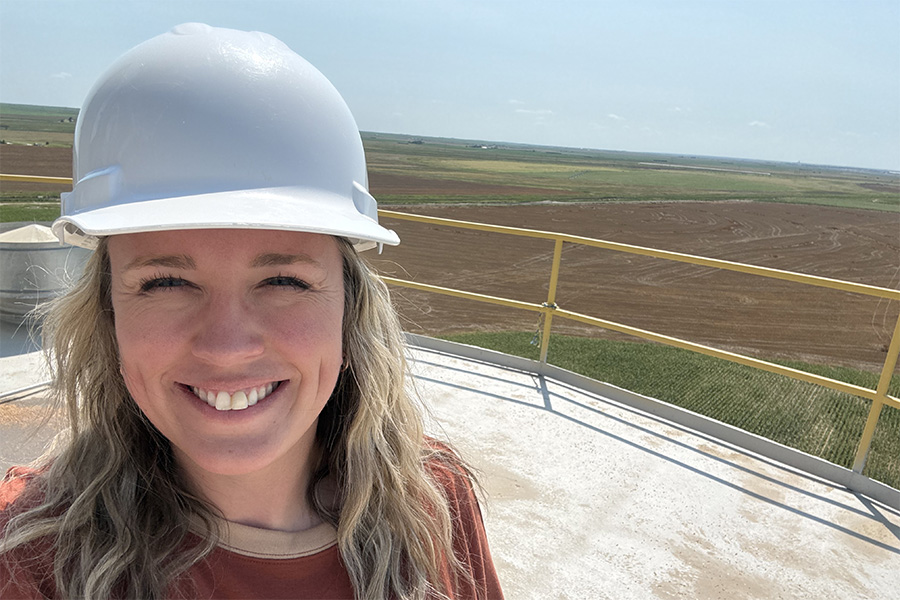 Lindy McMillen takes a selfie on top of a grain elevator that overlooks Kansas farmland.